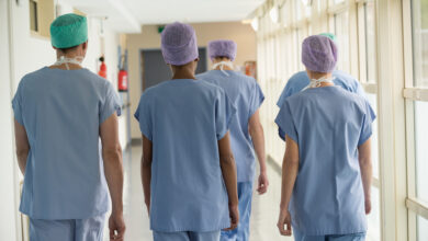 Rear view of a medical team walking in the corridor of a hospital